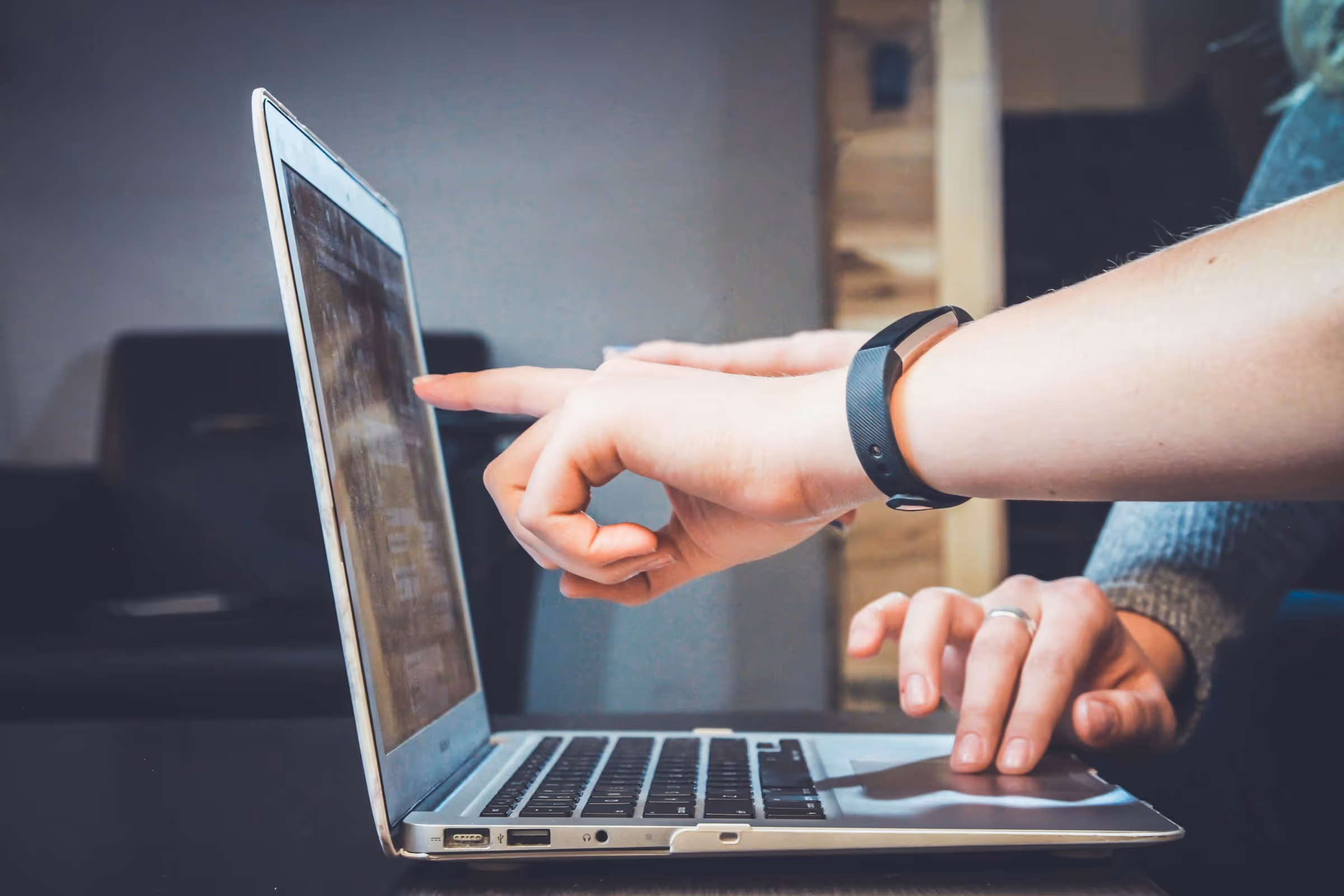 Two people reviewing an all-in-one marketing platform on a laptop